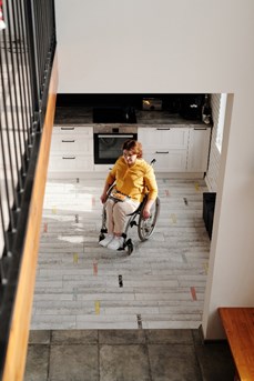 Une personne en chaise roulante dans sa cuisine adaptée